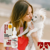 Kaley Cuoco holding a small white dog next to a bottle of Stop Effing Itching! supplement for dogs