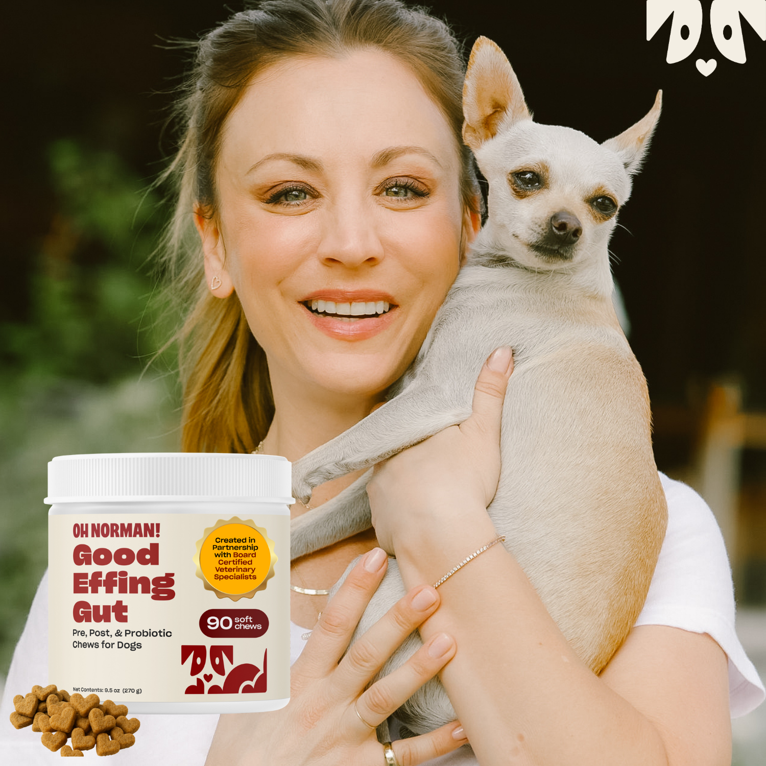 Kaley smiling and holding a small white dog and a package of Good Effing Gut supplement.